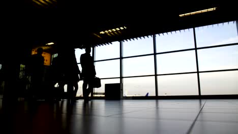 Delegation-von-Geschäftsleuten-zu-Fuß-zum-Gate-am-Flughafen,-Reisen,-Silhouetten