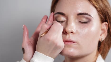 close-up-shot-of-the-makeup-artist-who-uses-dark-eyeliner-to-emphasize-the-eyes