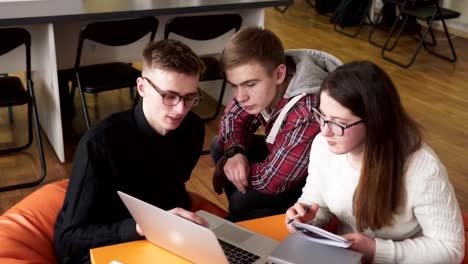 Young-male-student-showing-something-to-his-friends-on-a-laptop