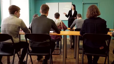 Frau-Lehrer-im-Gespräch-mit-Studenten-während-des-Unterrichts-an-der-Universität