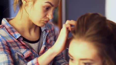 blonde-stylist-girl-makes-hairstyle-to-a-young-woman