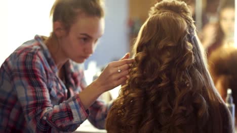 blonde-stylist-girl-makes-hairstyle-to-a-young-woman