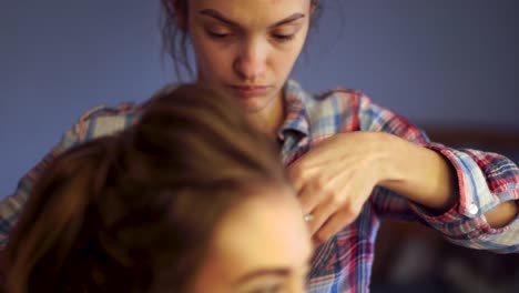 blonde-stylist-girl-makes-hairstyle-to-a-young-woman