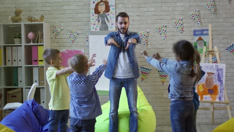 Lehrer-und-Kinder-körperliche-Übungen-im-Kindergarten