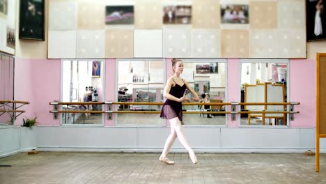 en-baile-de-salón,-joven-bailarina-en-leotardo-negro-realiza-pas-courru,-pointe,-ella-se-está-moviendo-a-través-de-la-clase-de-ballet-con-elegancia