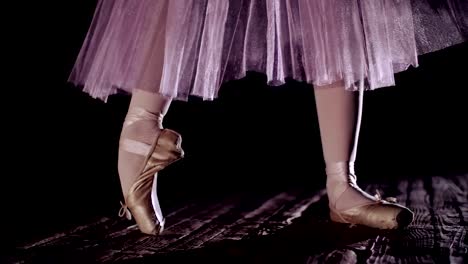 cerca,-en-los-rayos-de-luz,-en-el-escenario-de-la-antigua-sala-de-teatro.-bailarina-en-la-falda-de-ballet-blanco,-levanta-a-los-pies-en-los-zapatos-del-pointe,-elegantemente-realiza-un-cierto-ejercicio-de-ballet,-pointe,-tendu