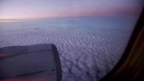 Nubes-púrpura-vistas-a-través-de-la-ventana-del-avión-a-reacción-en-la-puesta-de-sol.-HD-vídeo-alta-definición