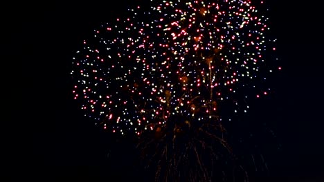 Fuegos-artificiales-en-la-ciudad-de-fiesta-del-día,-grandes-explosiones-de-fuegos-artificiales-en-el-cielo-nocturno.-Fuera-de-foco