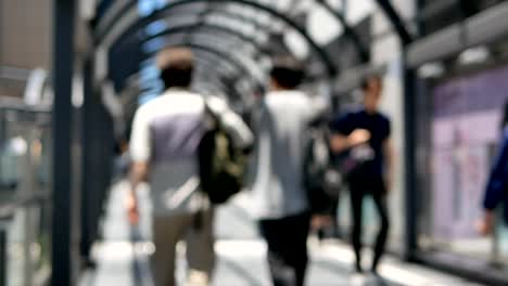 Multitud-anónima-de-personas-caminando-en-el-camino-a-pie-en-hora-punta-en-la-estación-de-Osaka,-Japón