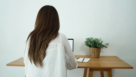 Hermosa-joven-sonriente-mujer-asiática-trabajando-en-ordenador-portátil-mientras-está-sentado-en-una-sala-de-estar-en-casa.-Mujer-de-negocios-asiáticos-trabajando-en-su-oficina-en-casa.-Disfrutando-en-casa.