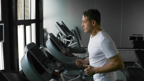 Athletic-Sportsman-Running-on-Treadmill-in-Gym