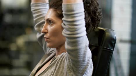 Motivated-Woman-Exercising-with-Dumbbells-in-Gym