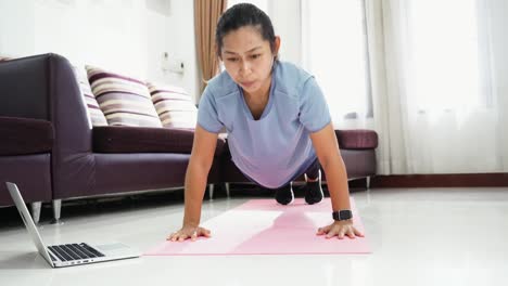 Ejercicio-de-mujeres-asiáticas-haciendo-empuja-hacia-arriba-el-entrenamiento-en-casa