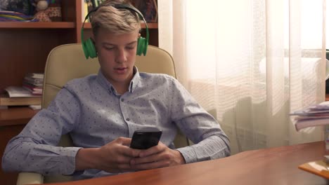 Young-guy-sits-in-a-leather-chair-and-listens-to-music