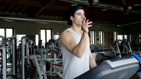 A-shirtless-guy-at-the-gym,-trains-his-body-to-stay-fit-and-have-defined-muscles.-The-athlete-raises-heavy-weights-and-fatigue.