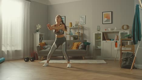Beautiful-Busty-Athletic-Fitness-Girl-in-Sportswear-is-Doing-Cardio-Exercises-in-Her-Sunny-and-Spacious-Apartment-with-Minimalistic-Interior.