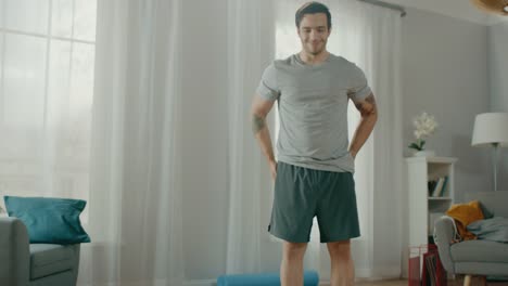 Strong-Muscular-Athletic-Fit-Man-in-T-shirt-and-Shorts-is-Doing-Mountain-Climber-Exercises-at-Home-in-His-Spacious-and-Bright-Apartment-with-Minimalistic-Interior.