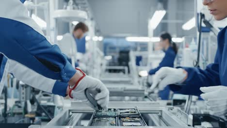 Time-Lapse-of-Electronics-Factory-Workers-Assembling-Smartphone-Circuit-Boards-by-Hand-While-they-Move-on-the-Assembly-Line.-High-Tech-Factory-Facility.