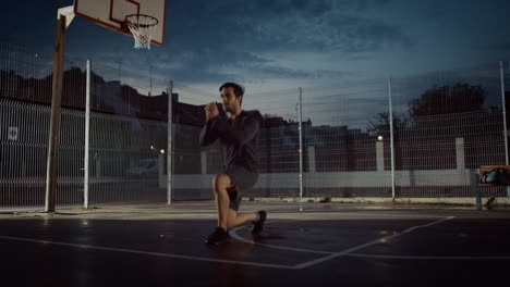 Fuerte-Muscular-forma-joven-en-traje-de-deporte,-haciendo-ejercicios-de-estocada-hacia-adelante.-Está-realizando-un-entrenamiento-en-una-cancha-de-baloncesto-al-aire-libre-cercado.-Imágenes-de-noche-después-de-la-lluvia-en-una-zona-de-barrio-residencial