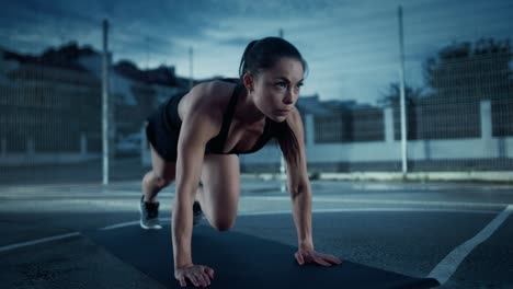 Beautiful-Energetic-Fitness-Girl-Doing-Mountain-Climber-Exercises.-She-is-Doing-a-Workout-in-a-Fenced-Outdoor-Basketball-Court.-Evening-Footage-After-Rain-in-a-Residential-Neighborhood-Area.