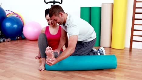 Trainer-working-with-woman-on-exercise-mat