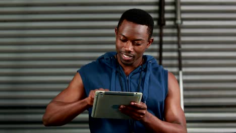 Fit-man-using-tablet-and-smiling-at-the-camera