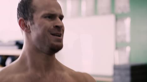 Close-up-of-a-fit-young-man-doing-squats-with-a-kettle-bell-in-a-small-gym