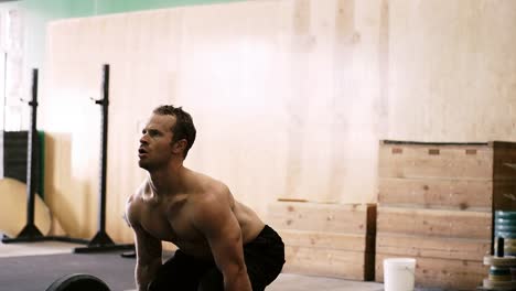 Una-forma-de-hombre-joven-haciendo-muertos-ascensores-en-un-pequeño-gimnasio