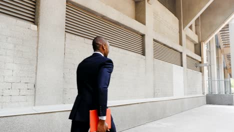 African-American-businessman-walk-with-tablet-outdoors