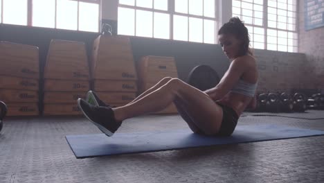 Mujer-fitness-trabajando-hacia-fuera-en-los-músculos-en-el-gimnasio