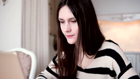 closeup-hands-of-young-woman-uses-laptop-in-a-bright-dining