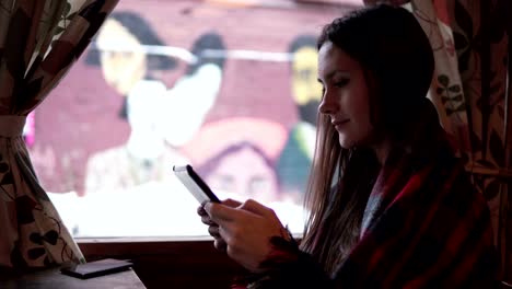 Beautiful-young-girl-using-tablet-computer-touchscreen-in-cafe