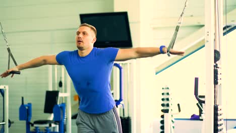 Handsome-sporty-man-is-exercising-in-fitness-club-and-gym-center