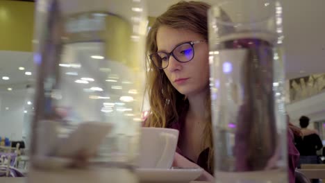 Mujer-utilizando-la-tablet-en-la-tienda-de-café.