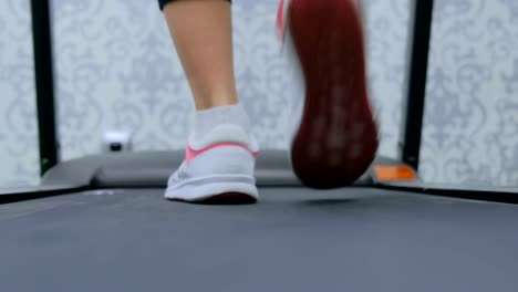 Athletic-young-woman-running-on-treadmill-at-the-gym