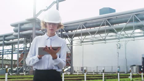 Mujer-en-Hard-Hat-es-caminar-y-usar-Tablet-PC-en-entorno-industrial