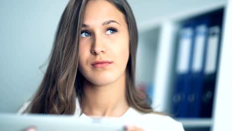 Attractive-businesswoman-using-a-digital-tablet-in-office