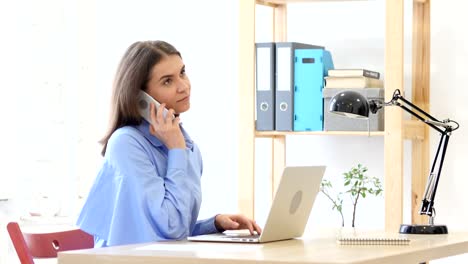 Woman-Talking-on-Phone-at-Work-with-Customer