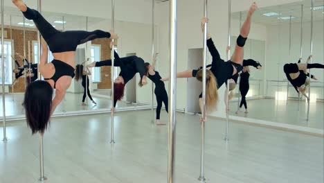 Fünf-sexy-schlanke-Frauen-Team-Poledance-training-im-Tanzsaal