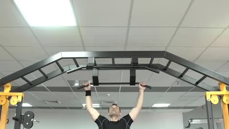 Strong-man-doing-pull-ups-in-a-gym