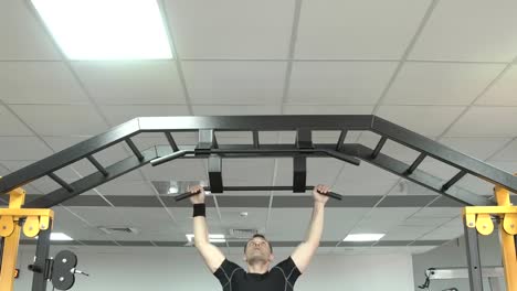 Starker-Mann-tun-Pull-ups-in-einem-Fitnessstudio