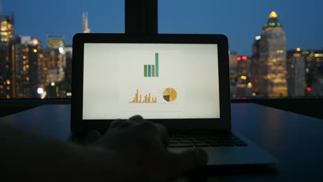 Digital-Device-Computer-with-Business-Figures-and-Banking-District-in-the-Background.