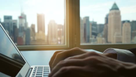 Business-Man-Using-Computer-with-Charts,-Diagrams,-Graphs-and-Figures.-Typing-on-Keyboard-of-Laptop.-Cityscape-in-the-Background.