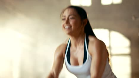 Athletic-Female-in-a-Gym-Exercises-with-Battle-Ropes-During-Her-Cross-Fitness-Workout/-High-Intensity-Interval-Training.-She's-Muscular-and-Sweaty,-Gym-is-in-Industrial-Building.