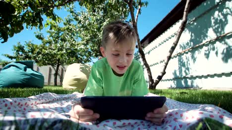 Boy-communicating-with-tablet-in-garden