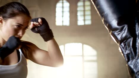 Woman-Fighter-Training-with-Punching-Bag-that-Her-Partner-Holds.-She's-Athletic-and-Has-Powerful-Punch.