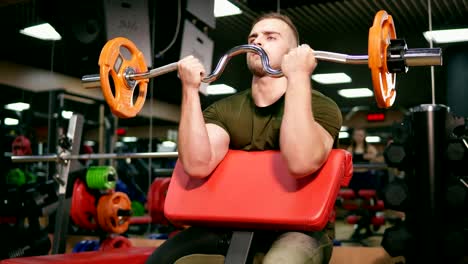 Junge-Erwachsene-Bodybuilder-training-seinen-Bizeps-in-Turnhalle-Gewichtheben-zu-tun.-Am-Rande-der-Möglichkeiten.-Schuss-in-4k