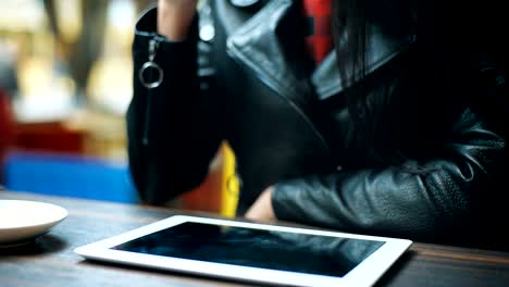 Legt-Frau-Hand-eine-Tasse-Kaffee-in-der-Nähe-der-Tablette-im-café