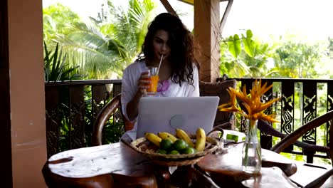 Young-Girl-Use-Laptopn-Computer-On-Summer-Terrace-During-Breakfast,-Beautiful-WomanTypung-Keyboard-While-Drinking-Juice