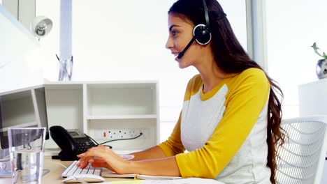 Führungskraft-mit-Headsets,-die-mit-dem-Computer-am-Schreibtisch-im-Büro-4k